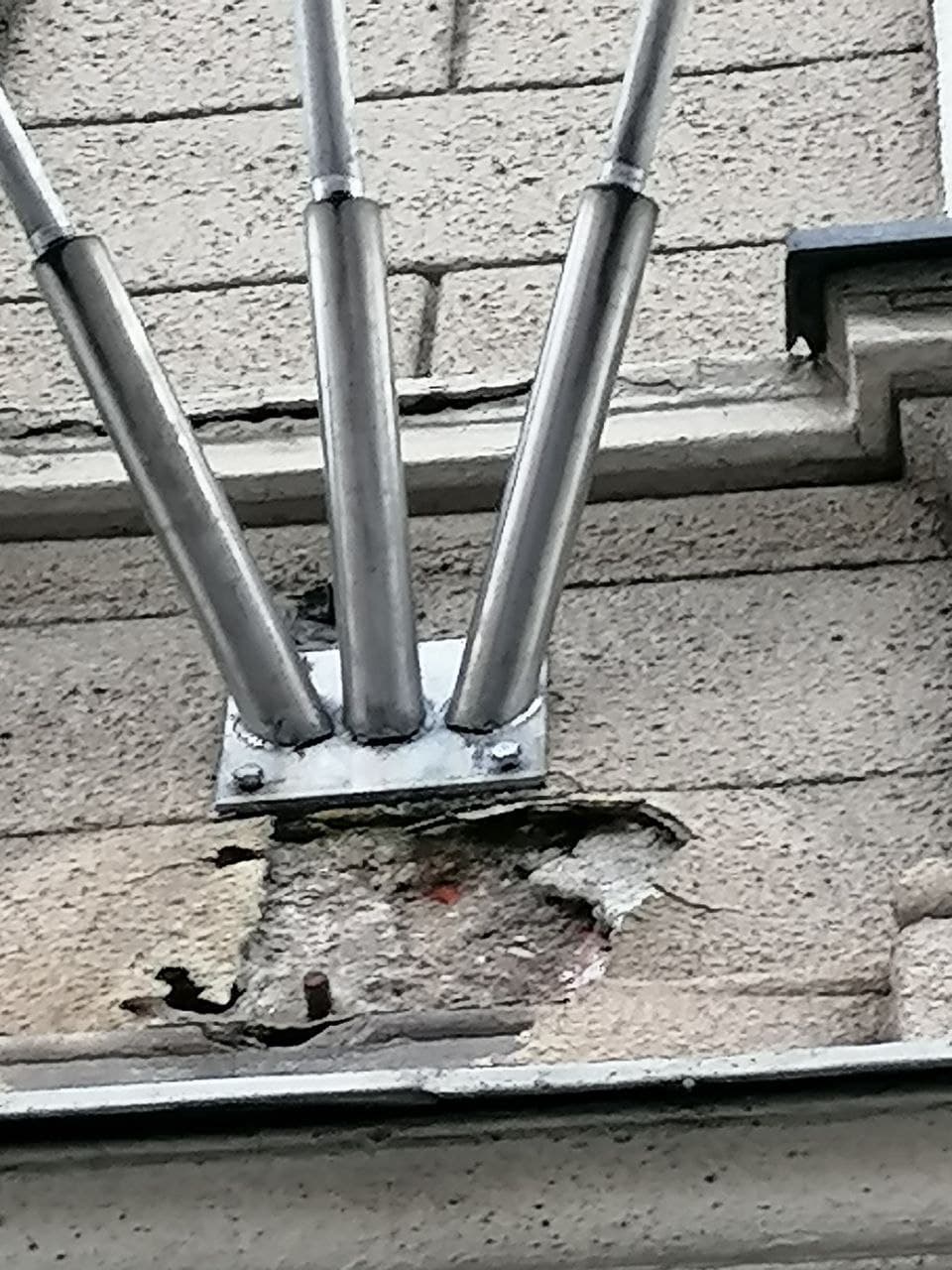 Umazana in poškodovana fasada pod nosilcem zastave